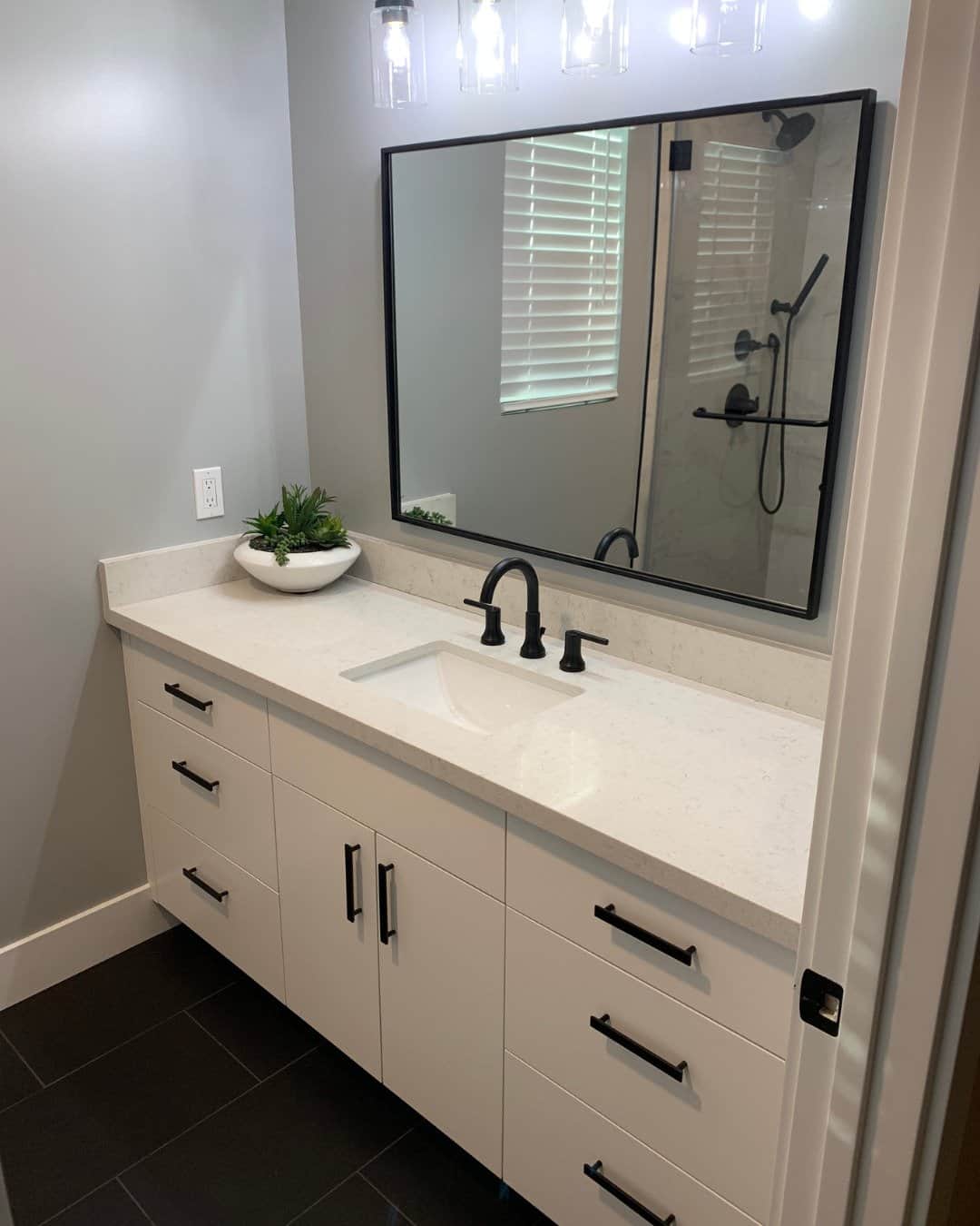 Modern bathroom renovation in San Carlos, CA featuring a white floating-style vanity, matte black faucet and hardware, and white quartz countertops