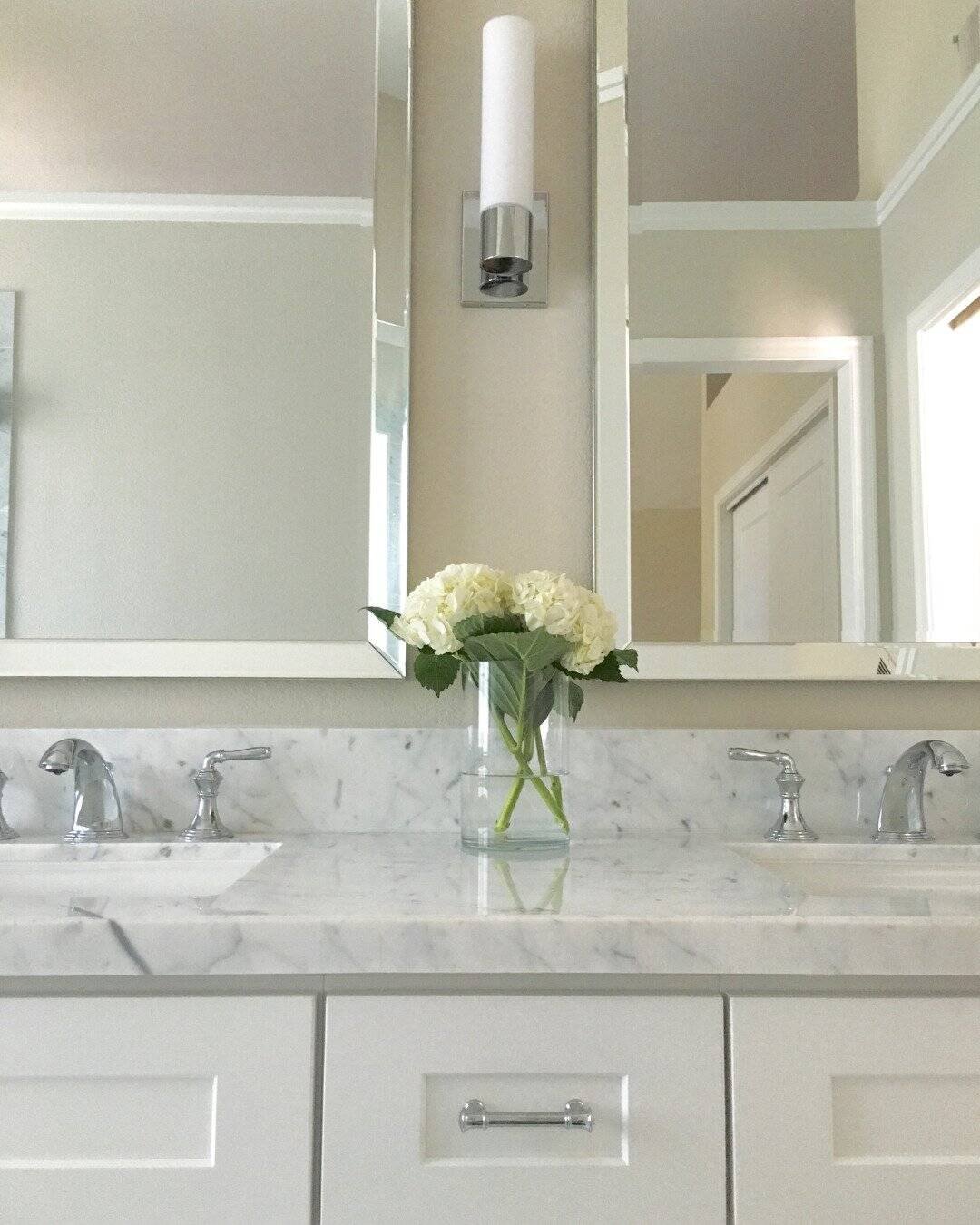 Luxury bathroom remodel in San Carlos, CA featuring a double vanity with marble countertops and white shaker cabinets.