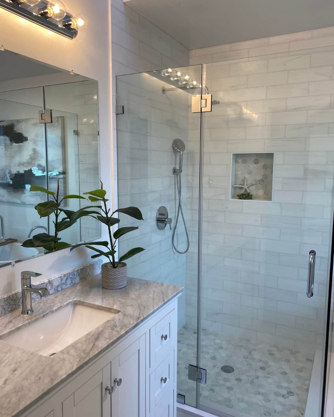 Modern bathroom remodel in San Carlos, CA featuring a walk-in shower with a frameless glass door, white subway tile, and a white vanity with a marble countertop