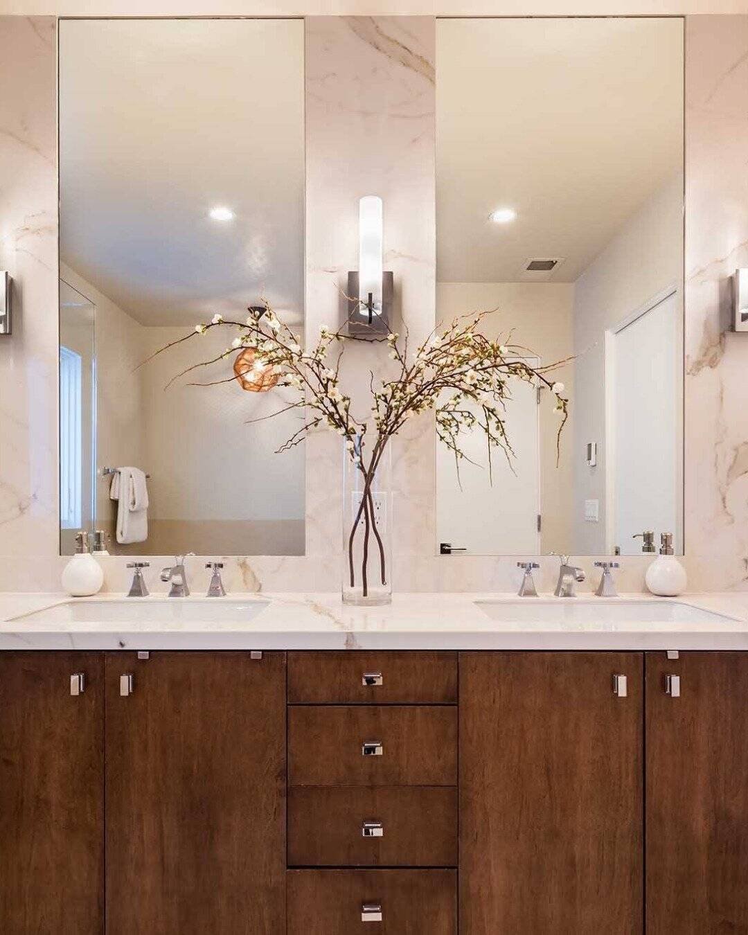Modern bathroom remodel in San Carlos, CA featuring a dark wood double vanity with white marble countertops and a matching marble-tiled wall with dual mirrors