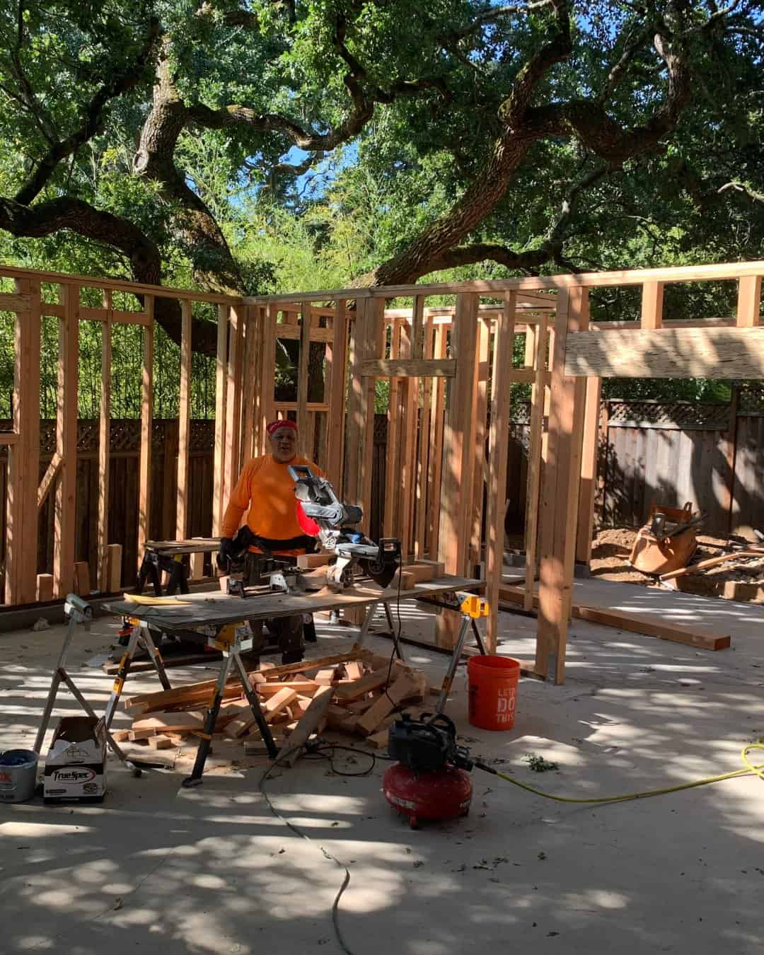 General contractor cutting lumber with a miter saw during a residential home addition framing project in San Carlos, CA.