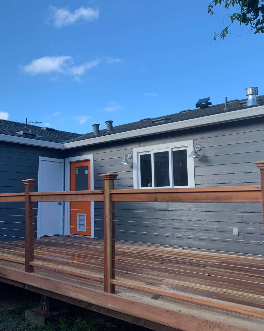 Custom redwood deck installation with modern cable railing for a residential remodeling project in San Carlos, CA.
