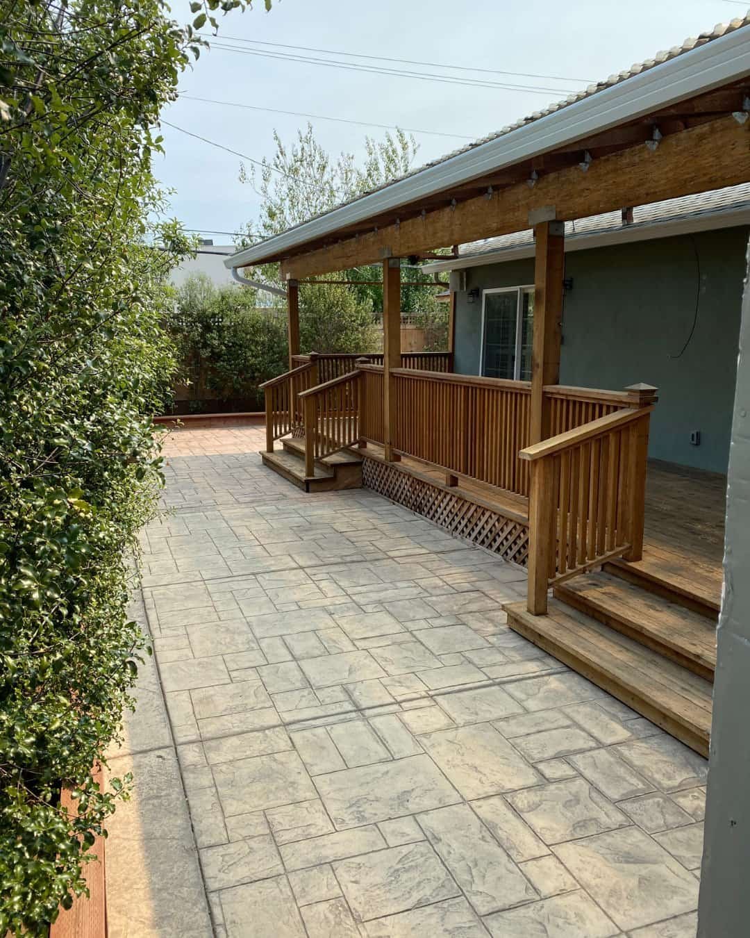 Custom wooden deck with pergola and stamped concrete patio renovation in San Carlos, CA.