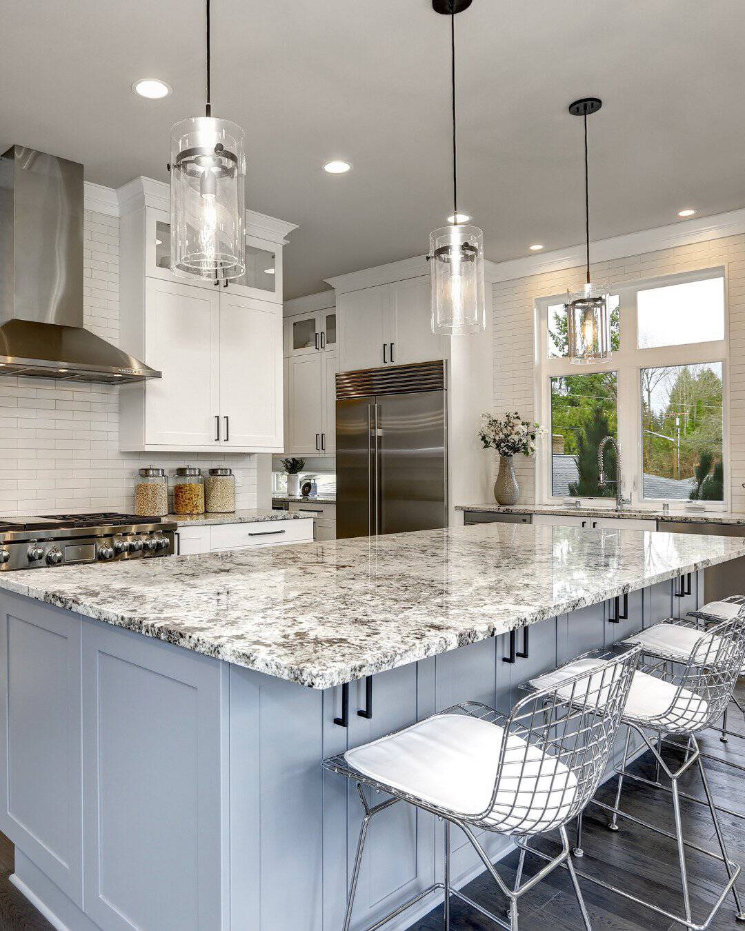 Luxury kitchen remodel in San Carlos, CA by Genuine Kitchen and Bath, featuring a light blue island with granite countertops, white shaker cabinets, and professional stainless steel appliances